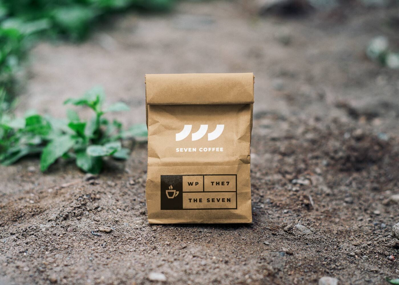 A brown bag sitting on the ground with some plants in it