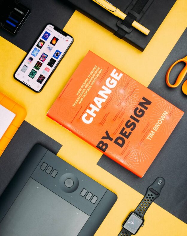 A book is laying on the table next to some other items.