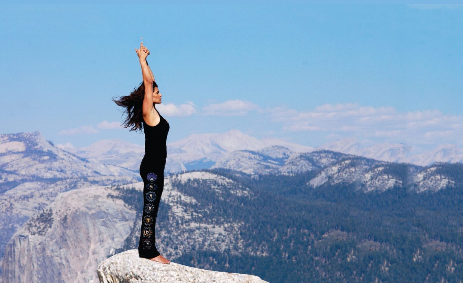A woman doing yoga on a mountaintop