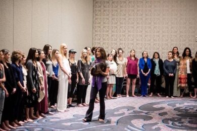 A group of women standing in front of a woman.