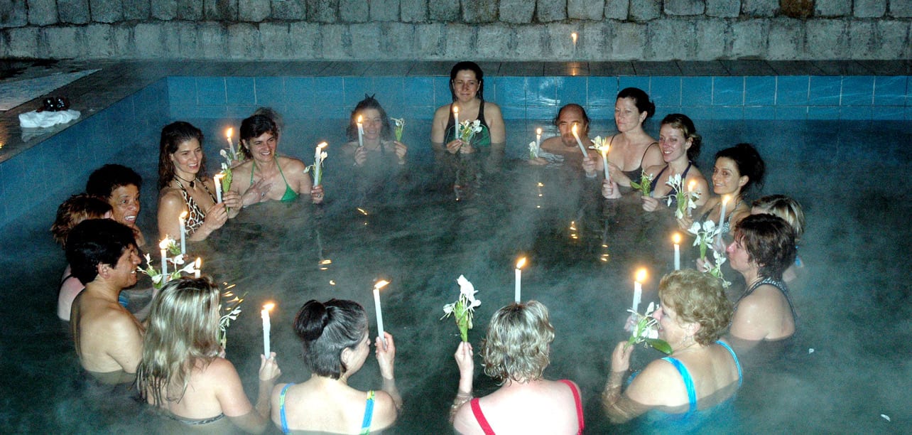 A group of women in the water with candles.