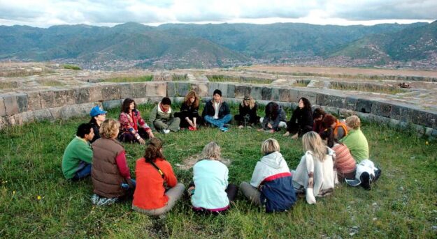 A group of people sitting in the grass.