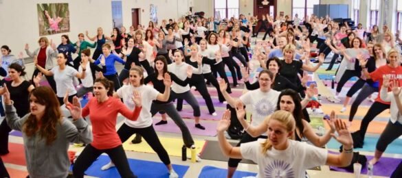 A group of people doing yoga poses in the gym.