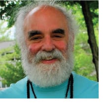 A man with white beard and blue shirt.