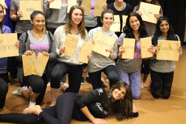 A group of people holding up papers in front of each other.