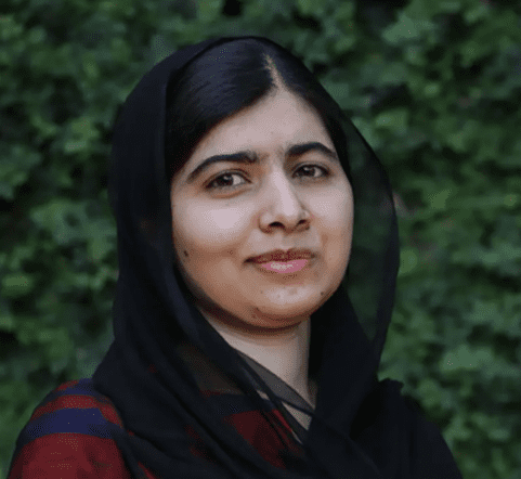 A woman with black hair and a veil on her head.