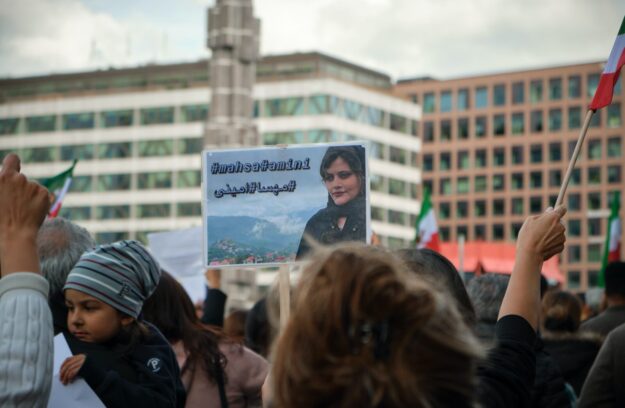 A person holding up a sign in front of a crowd.