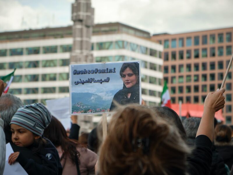 A person holding up a sign in front of a crowd.