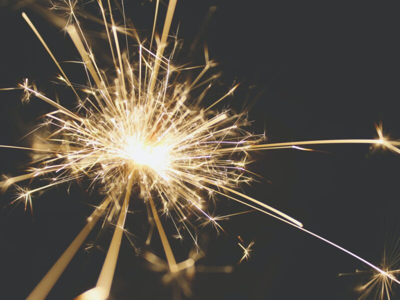 A sparkler is lit up on the night sky.