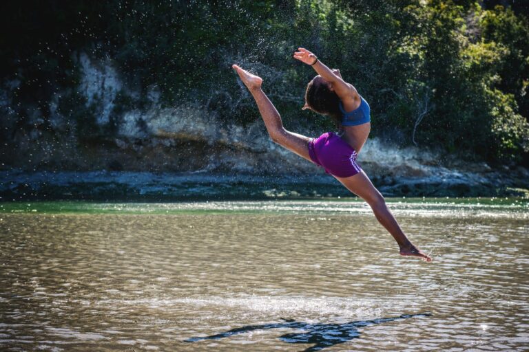 A person jumping in the air over water.
