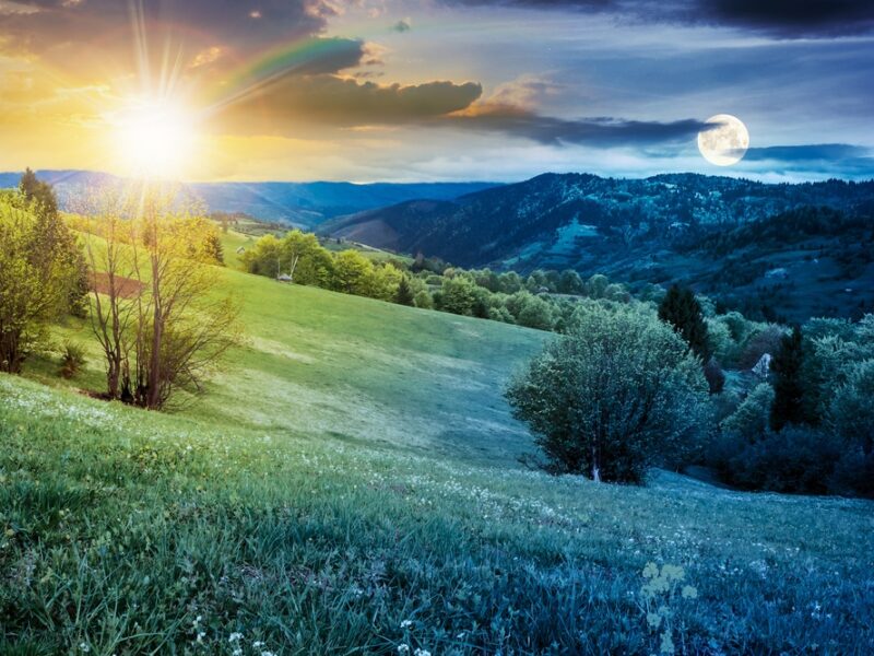 A beautiful sunset over the mountains with trees in the foreground.