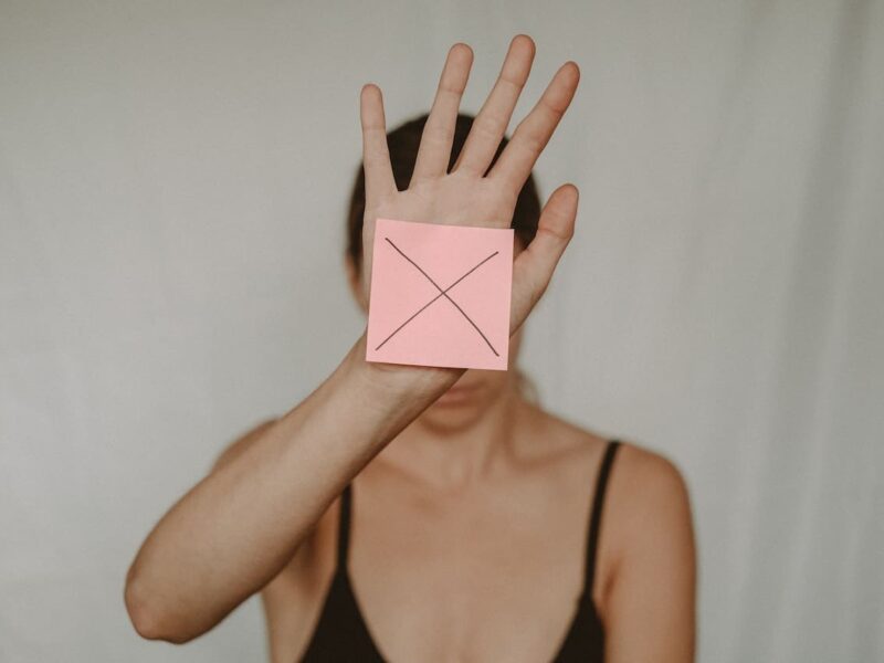 A woman holding up her hands with an x on it.