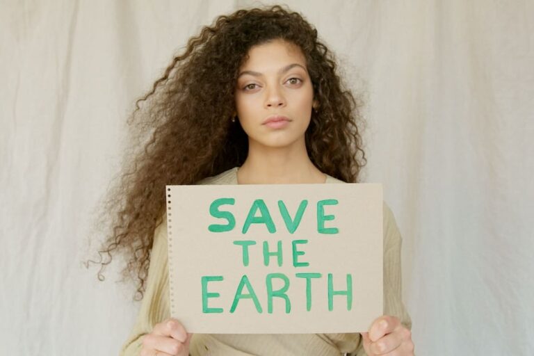 A woman holding up a sign that says save the earth.