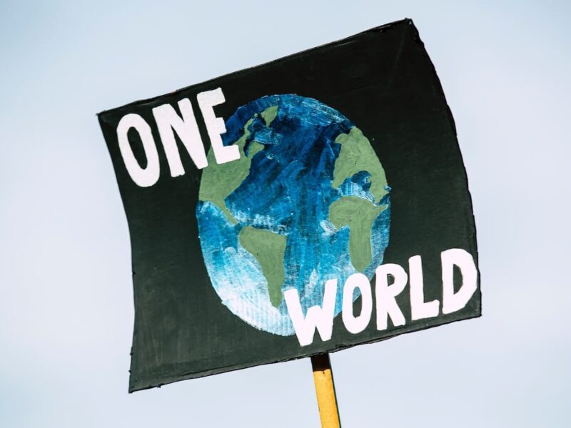 A sign with the words one world on it.