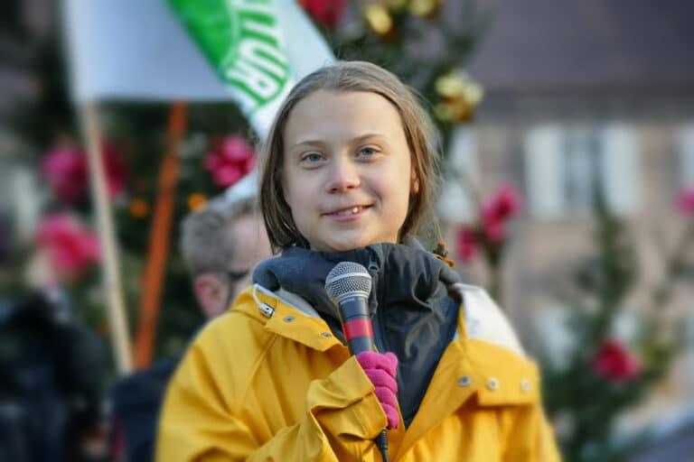 A young girl is holding a microphone and smiling.