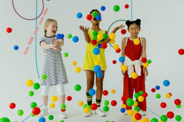 Three children are playing with balls in a room.