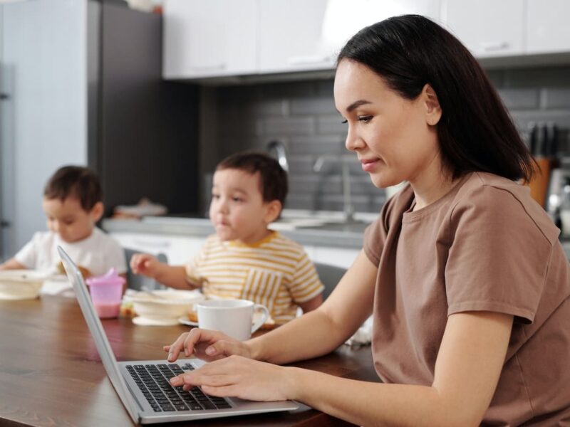 A woman is using her laptop while sitting at the table