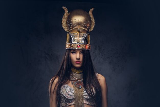 A woman wearing a gold helmet and posing for the camera.