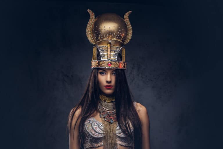 A woman wearing a gold helmet and posing for the camera.
